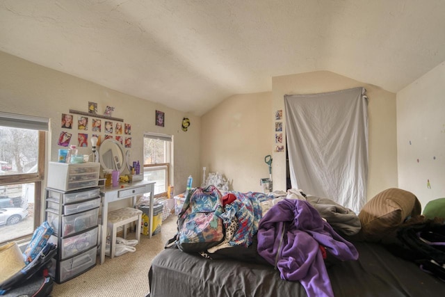 carpeted bedroom with a textured ceiling and vaulted ceiling