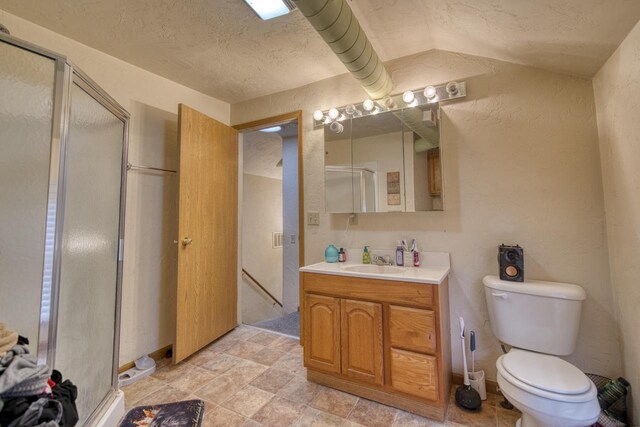 bathroom featuring walk in shower, vanity, lofted ceiling, and toilet