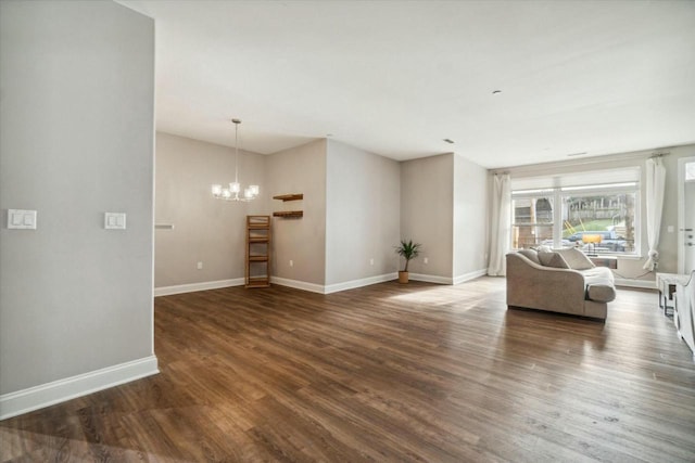 unfurnished living room with dark wood-type flooring and a notable chandelier