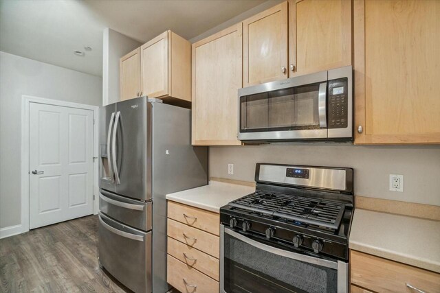 kitchen featuring dark hardwood / wood-style flooring, stainless steel appliances, and light brown cabinetry