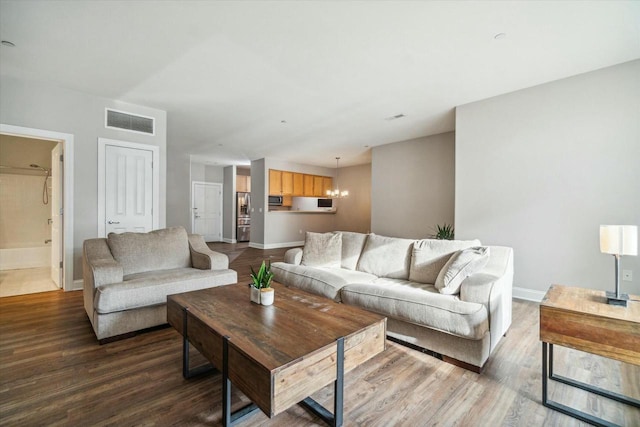 living room with a chandelier and wood-type flooring