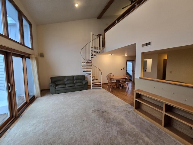 living room featuring beam ceiling, hardwood / wood-style flooring, high vaulted ceiling, and ceiling fan