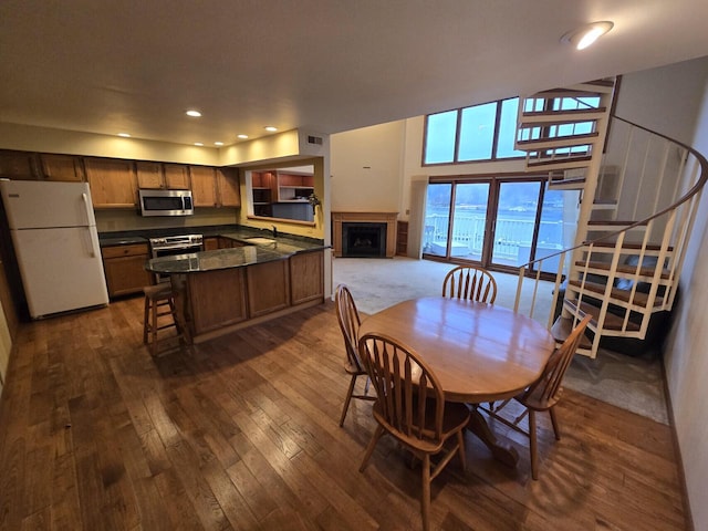 1470 S Delavan Club Dr Unit 6, Delavan, WI 53115 - dining room with a fireplace, dark wood-style flooring, stairway, and recessed lighting