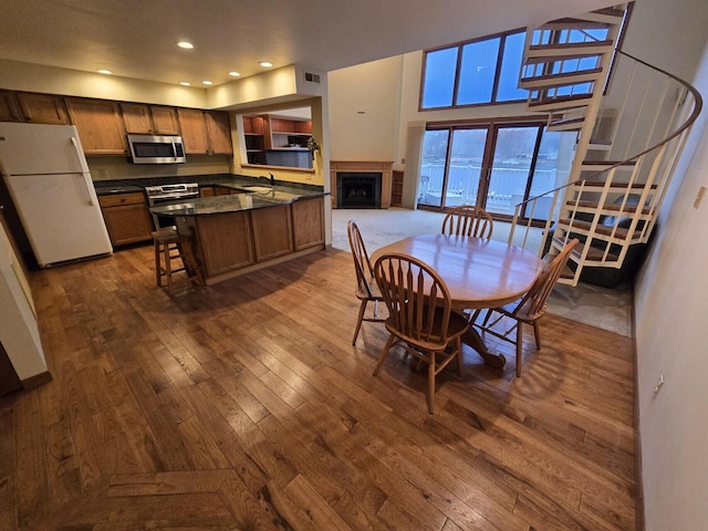 dining space with a high ceiling, hardwood / wood-style flooring, and sink