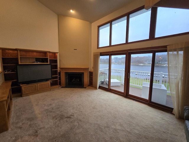 unfurnished living room with carpet, beamed ceiling, and high vaulted ceiling