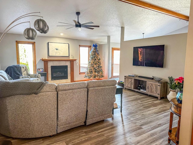 living room featuring a fireplace, wood-type flooring, and a textured ceiling