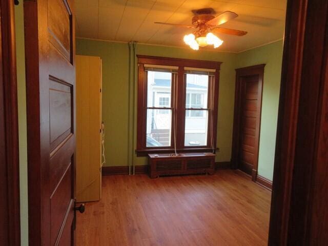 spare room featuring light hardwood / wood-style flooring, ceiling fan, and crown molding