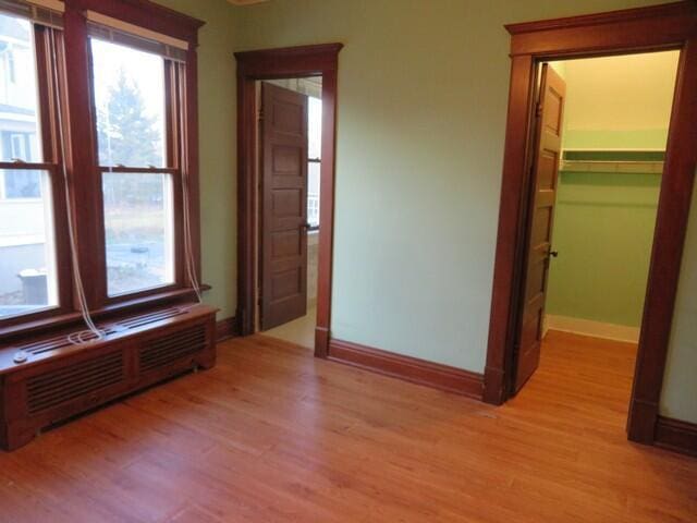 empty room with radiator heating unit and light wood-type flooring