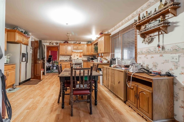 kitchen featuring range, light hardwood / wood-style flooring, and white fridge with ice dispenser