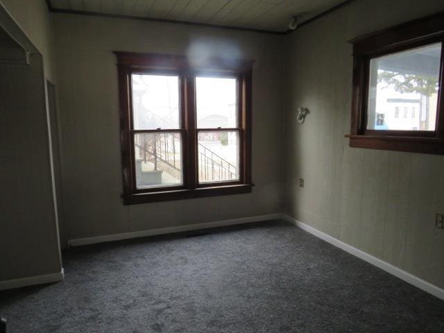 unfurnished room featuring carpet floors and wooden ceiling