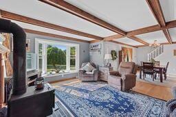 living room featuring beam ceiling, coffered ceiling, and a notable chandelier