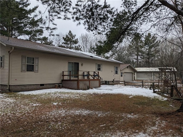 snow covered property featuring a wooden deck and a garage