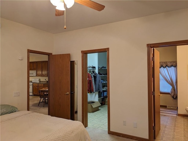 bedroom featuring a closet, a spacious closet, and ceiling fan