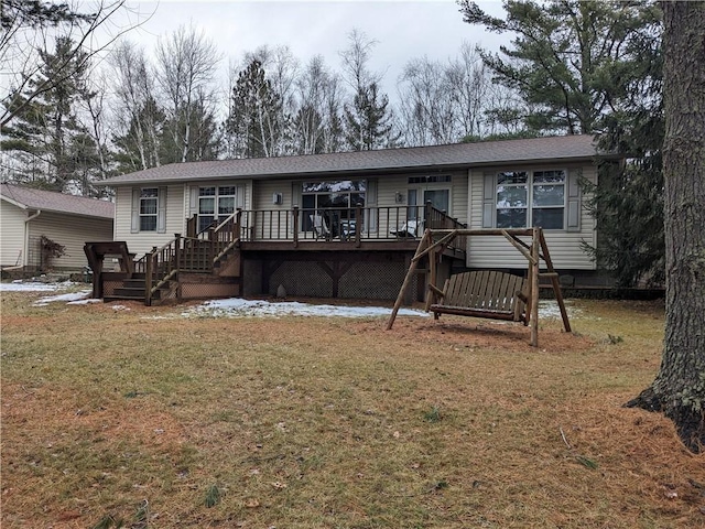 back of property with a wooden deck and a yard