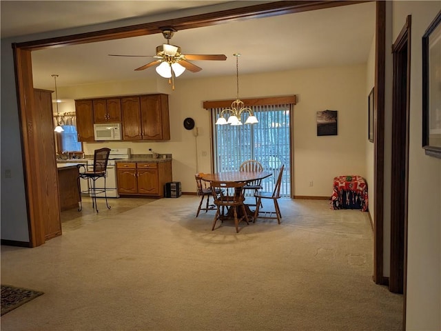 carpeted dining space with ceiling fan with notable chandelier