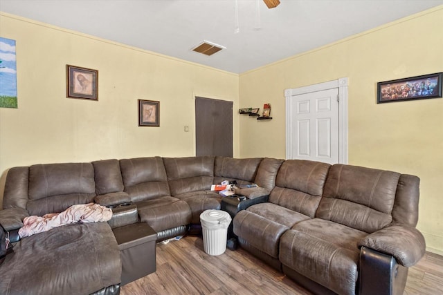 living room with ceiling fan, light wood-type flooring, and crown molding