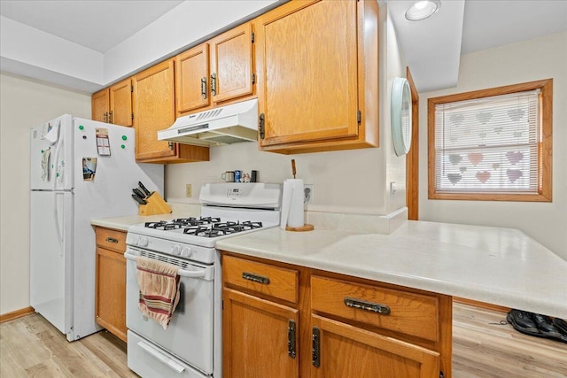 kitchen with white appliances and light hardwood / wood-style floors