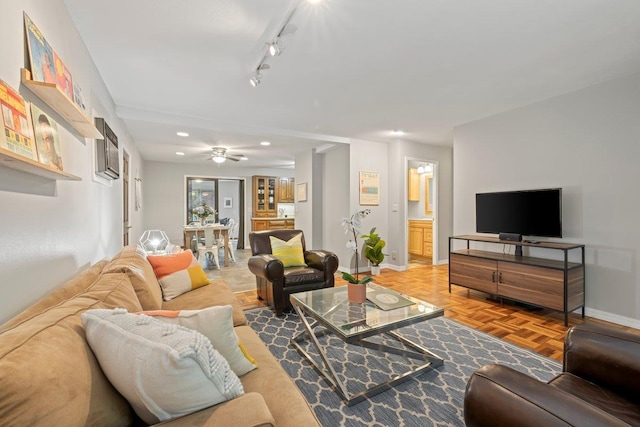 living room featuring ceiling fan, parquet flooring, and rail lighting