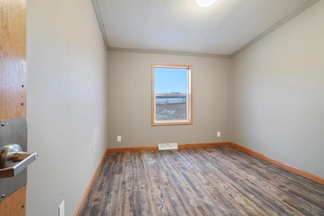 spare room with crown molding, wood-type flooring, and a textured ceiling