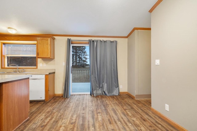 kitchen with dishwasher, crown molding, sink, and light hardwood / wood-style flooring