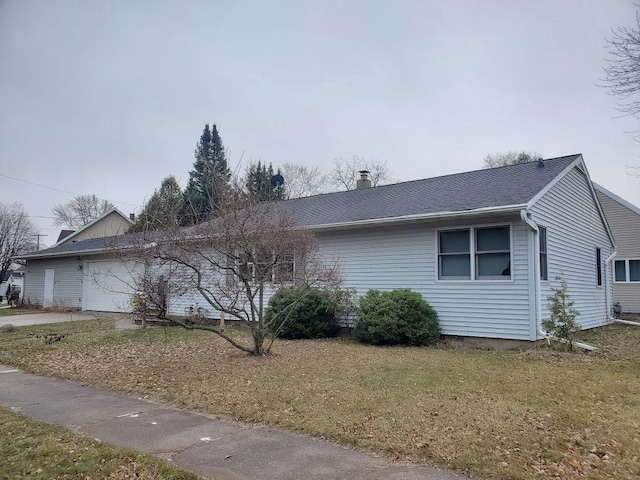 view of side of property with a yard and a garage