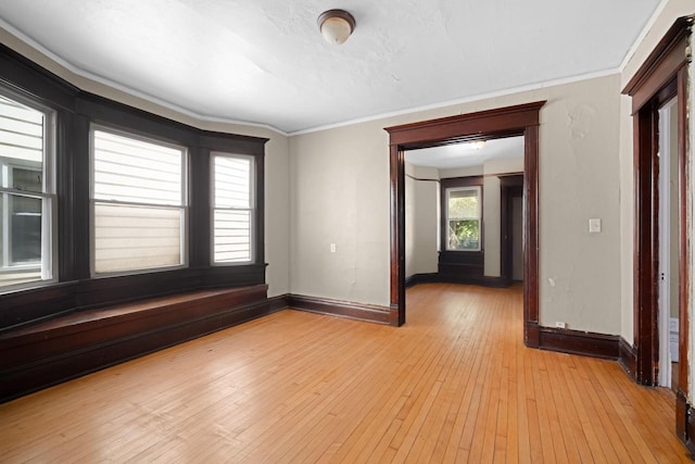 empty room featuring light hardwood / wood-style floors and ornamental molding