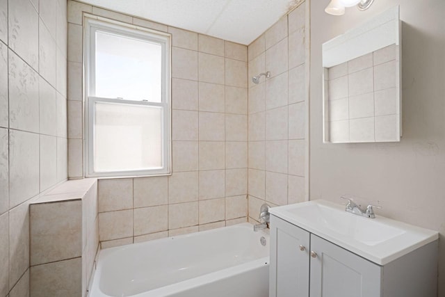 bathroom featuring vanity, tiled shower / bath combo, and a healthy amount of sunlight