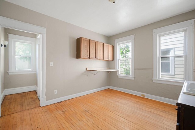 clothes washing area with light wood-type flooring