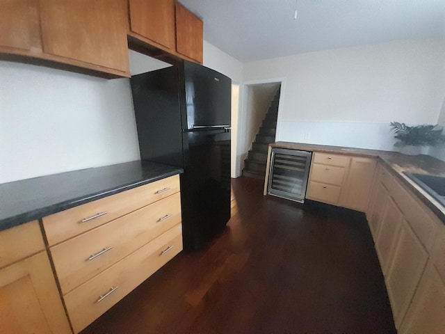 kitchen with wine cooler, black fridge, light brown cabinetry, and dark hardwood / wood-style floors