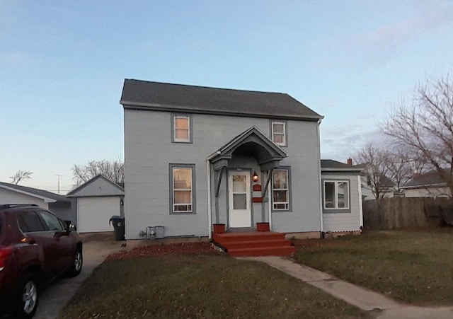 view of front facade featuring an outbuilding, a garage, and a front lawn