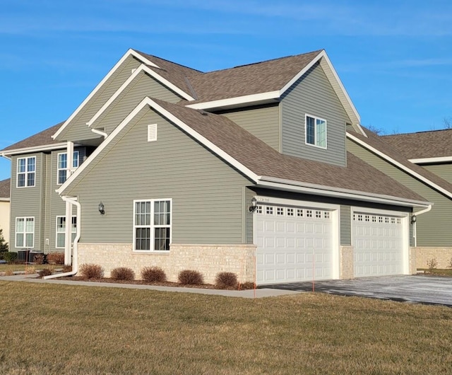 view of front of home with a garage and a front lawn