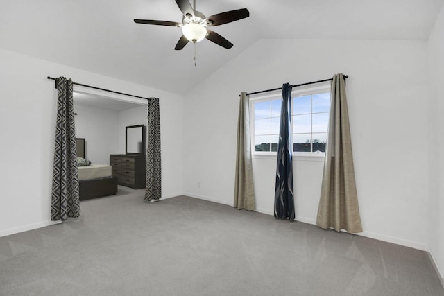 carpeted empty room with ceiling fan and vaulted ceiling