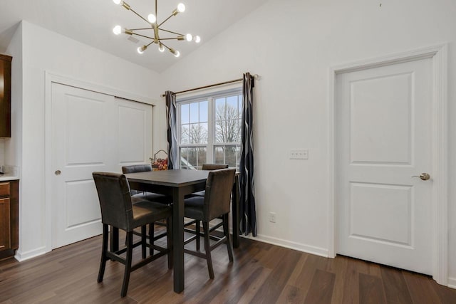 dining room with dark wood-type flooring, vaulted ceiling, and an inviting chandelier