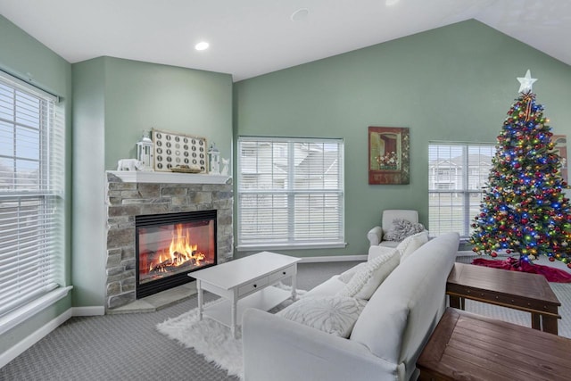 carpeted living room with a fireplace, plenty of natural light, and vaulted ceiling