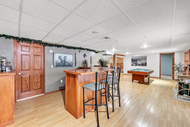 bar featuring a wall mounted air conditioner, a drop ceiling, pool table, light hardwood / wood-style floors, and butcher block counters