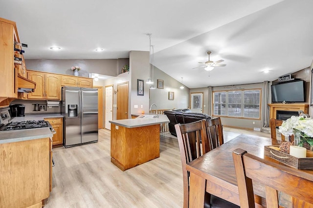 kitchen featuring sink, stainless steel appliances, light hardwood / wood-style flooring, lofted ceiling, and a kitchen island