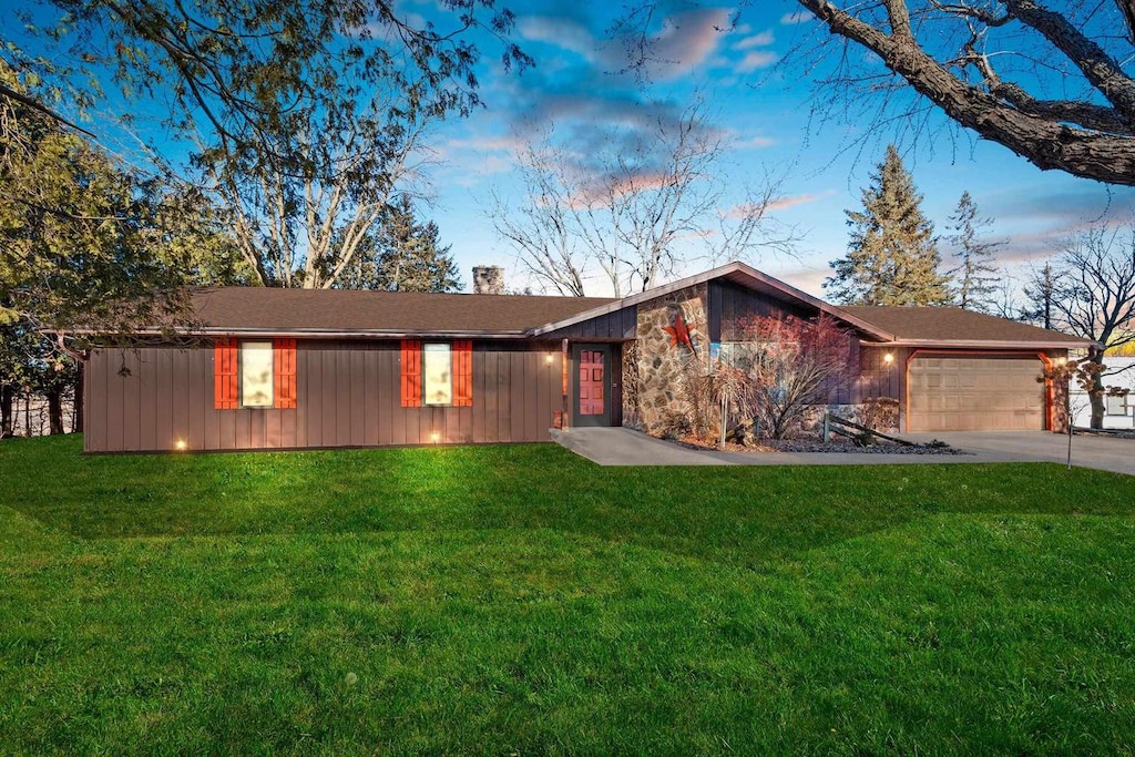 ranch-style home featuring a yard and a garage