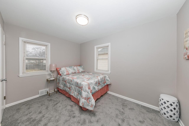 bedroom with multiple windows and light carpet