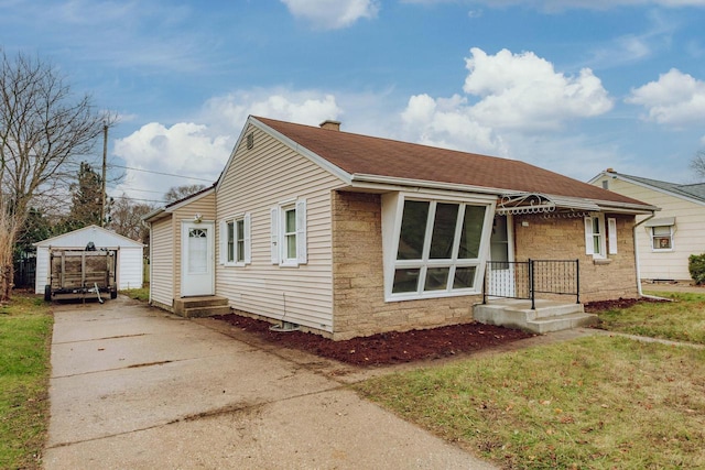 bungalow with an outbuilding and a front yard