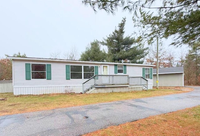 manufactured / mobile home with a front lawn and a deck