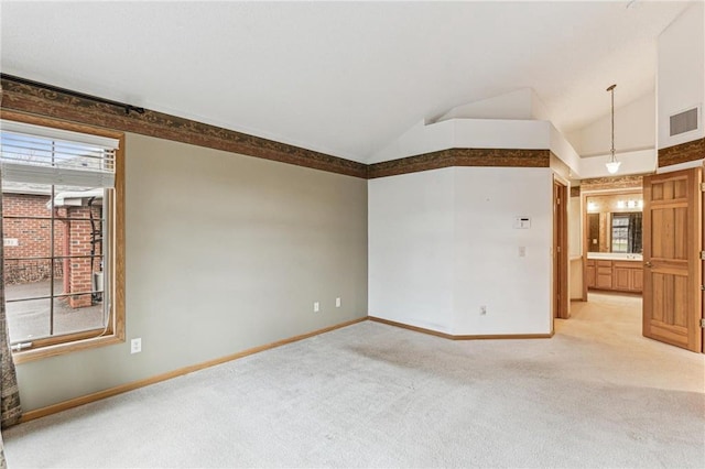 carpeted spare room with lofted ceiling