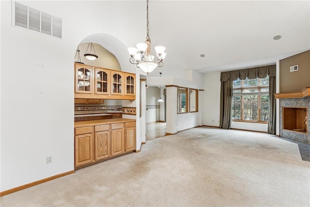 unfurnished living room with a chandelier and light carpet