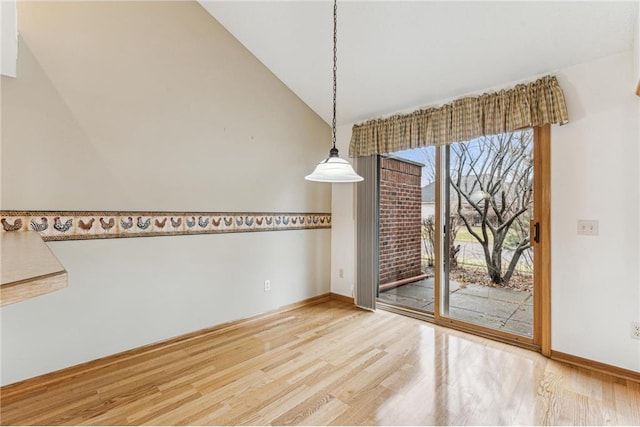 unfurnished dining area with lofted ceiling and hardwood / wood-style flooring