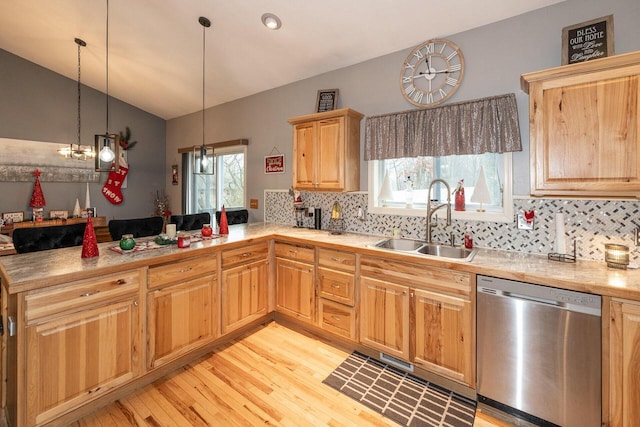 kitchen with light brown cabinets, a peninsula, a sink, light countertops, and dishwasher