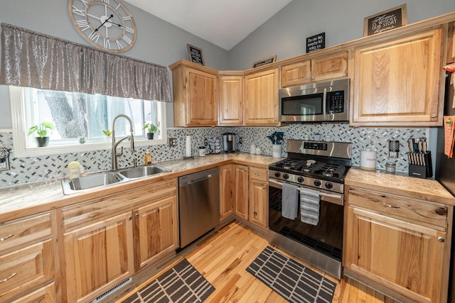W3769 Alder Dr, Lake Geneva, WI 53147 - kitchen with stainless steel appliances, vaulted ceiling, light countertops, light wood finished floors, and tasteful backsplash