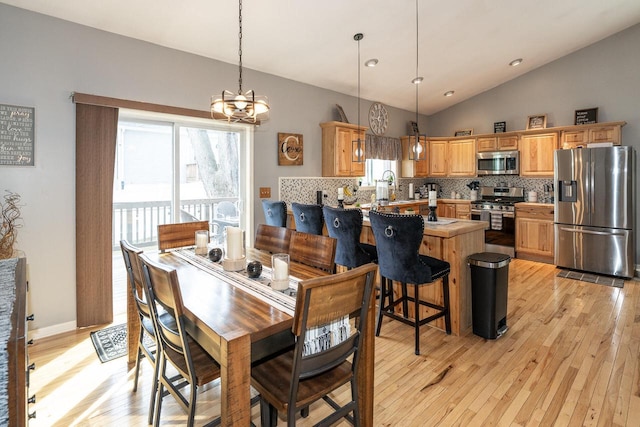 W3769 Alder Dr, Lake Geneva, WI 53147 - dining room featuring vaulted ceiling, light wood-type flooring, healthy amount of natural light, and a chandelier
