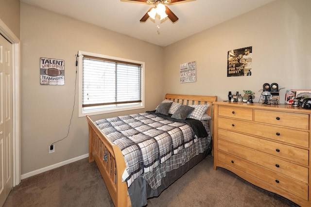 bedroom with dark carpet and baseboards