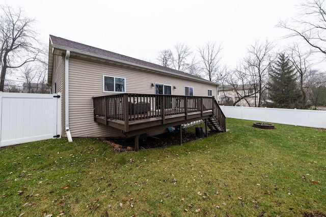 back of house featuring a deck, a fenced backyard, and a lawn