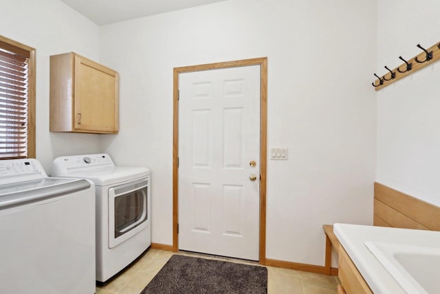 laundry area featuring light tile patterned flooring, cabinets, and independent washer and dryer