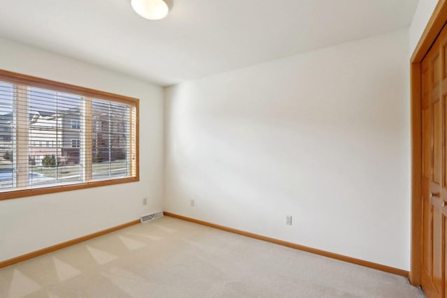 unfurnished bedroom featuring light colored carpet and a closet